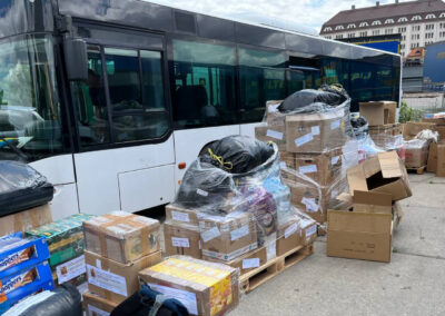 коробки та пакунки з гуманітарною допомогою для України на фоні автобуса